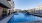 Large sparkling blue pool with a large pool deck and lounge chairs