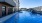 Large sparkling blue pool with a large pool deck and lounge chairs