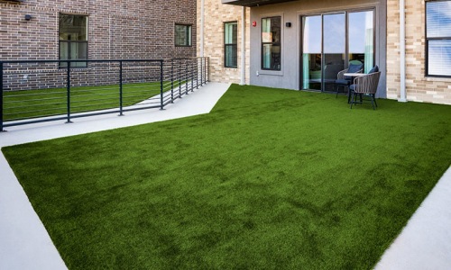 The terrace of The Drake apartments with lush green grass and plenty of room for kids and pets.