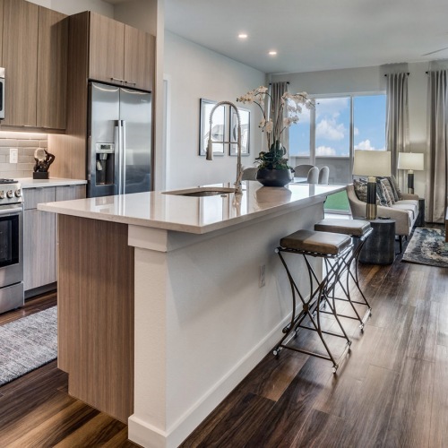 Kitchen  Large well lit kitchen with dark wood floors and granite countertops with stainless steel appliances.