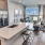 Large well lit kitchen with dark wood floors and granite countertops with stainless steel appliances. 