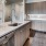 Large well lit kitchen with dark wood floors and granite countertops with stainless steel appliances at The Drake