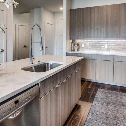 Kitchen  Large well lit kitchen with dark wood floors and granite countertops with stainless steel appliances at The Drake